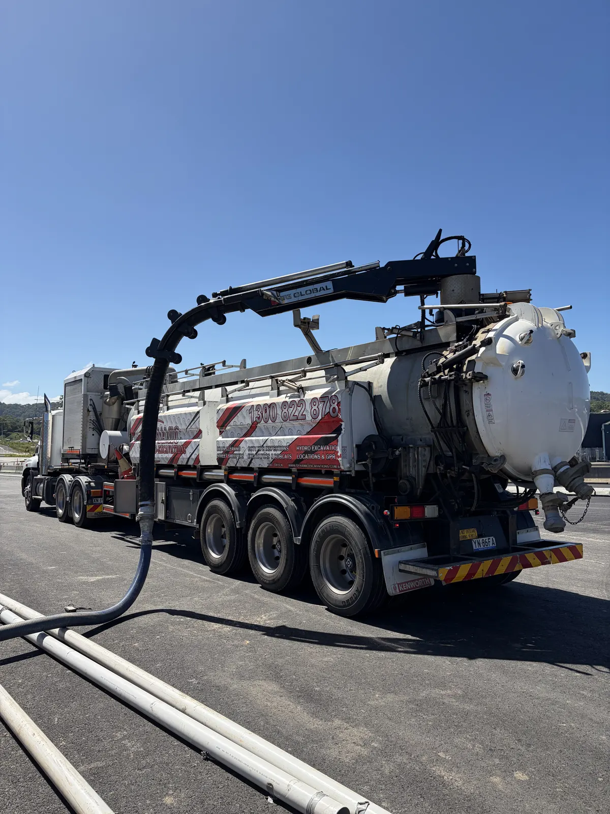 Dynamic Excavations hydro tanker semi-trailer with its suction hose stowed over the tank
