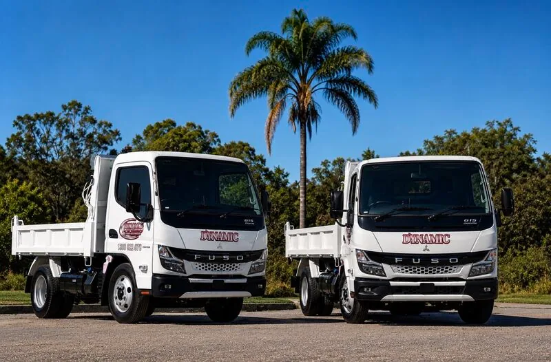 Two new white Fuso tipper trucks in Dynamic Hydro Excavations livery parked side by side