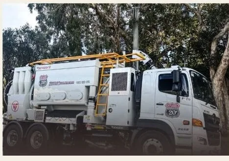 Vacvator air excavation unit mounted behind the cab of a Dynamic Hydro Excavations truck, with yellow handrails and an access ladder along the tank